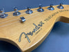 Close-up of Fender Telecaster Deluxe electric guitar headstock with tuning pegs and strings on natural wood finish