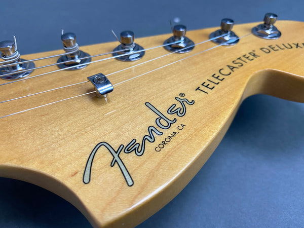 Close-up of Fender Telecaster Deluxe electric guitar headstock with tuning pegs and strings on natural wood finish