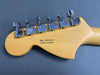 Close-up of Fender electric guitar headstock back with six chrome tuning pegs, serial number US20051123, made in Corona, California, light maple wood finish