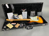 Fender Custom Shop sunburst electric guitar with maple neck inside black plush-lined hard case, including certificate of authenticity, Fender Custom Care booklet, warranty papers, coffee house guitars checklist, strap, and additional accessories.