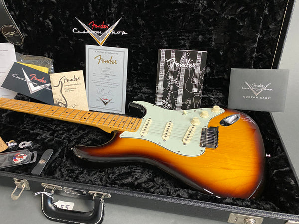 Fender Custom Shop sunburst electric guitar with maple neck in black plush-lined hard case, including Fender authenticity certificate and care manuals