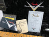 Fender Custom Shop certificate of authenticity for Custom DLx Stratocaster guitar, Fender Lacquer Finishes precaution and care booklet, black plush guitar case interior with Fender Custom Shop logo, and maple guitar neck.