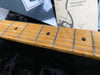 Close-up of maple guitar neck with metal frets and dot inlays, Fender Precautions and Care booklet in background, Coffee House Guitars product detail image