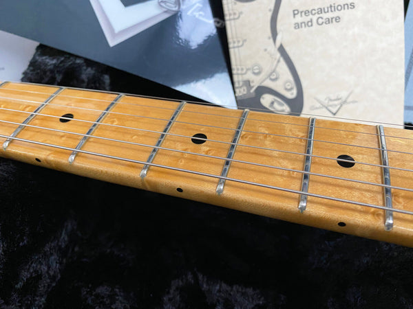 Close-up of maple guitar neck with metal frets and dot inlays, Fender Precautions and Care booklet in background, Coffee House Guitars product detail image