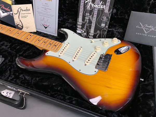 Fender Custom Deluxe Stratocaster electric guitar with sunburst finish, maple neck, and white pickguard in black plush case with Fender care and warranty documents