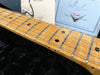 Close-up of maple guitar neck and frets with black dot inlays, Fender Custom Shop certificate in background, Coffee House Guitars product listing.