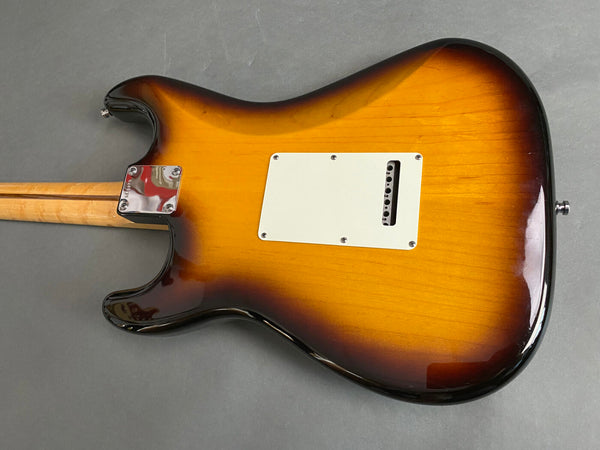 Rear view of sunburst electric guitar body with white backplate and maple neck on gray background