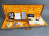 Fender vintage white electric guitar in open brown hard case with orange plush interior, warranty and Fender booklet, cleaning cloth, and certificate of authenticity displayed