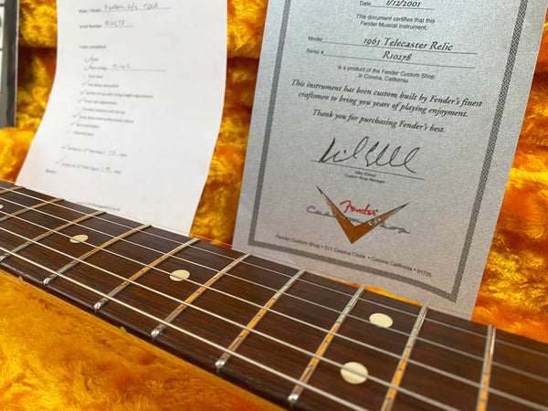 Close-up of Fender 1965 Telecaster Relic guitar neck and fretboard with certification documents in orange plush guitar case