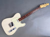Vintage white Fender Telecaster electric guitar with maple neck and rosewood fretboard on gray background