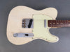 Vintage white electric guitar body with rosewood fretboard and aged finish showing wear and crackling