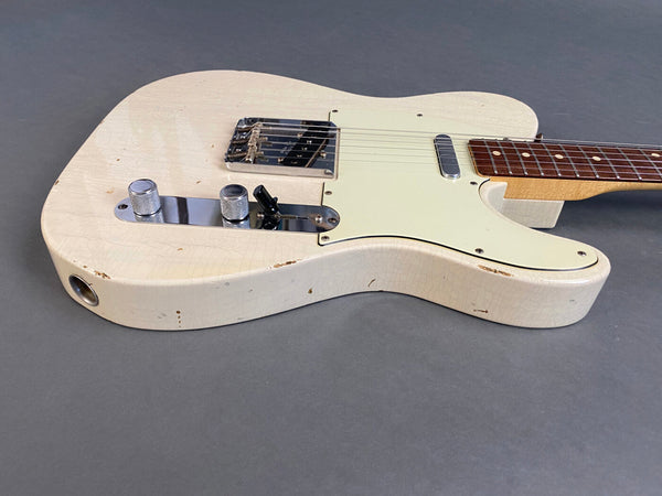 Close-up of vintage white electric guitar body with rosewood fretboard and aged finish showing wear and patina on gray background