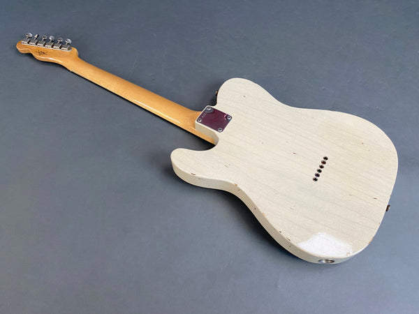 Back of vintage white electric guitar with a maple neck and six tuning pegs on the gray background