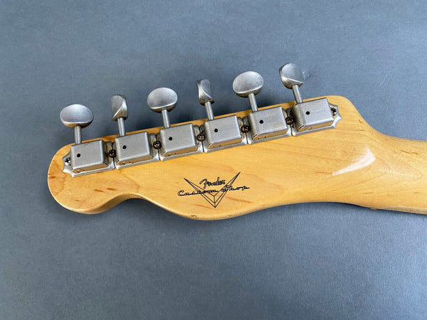 Vintage Fender Custom Shop guitar headstock with six vintage-style tuning pegs on natural wood finish against gray background