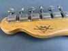 Close-up of vintage Fender Custom Shop electric guitar headstock tuners with aged metal tuning pegs on natural wood finish