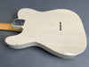 Vintage white electric guitar body with visible wear and relic finish showing cracks and scratches on gray background
