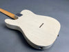Back view of vintage white electric guitar body with relic finish and wooden neck on gray background