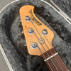 Ernie Ball Music Man StingRay bass guitar headstock with tuning pegs and strings in plush gray guitar case