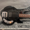 Black electric bass guitar with rosewood fretboard and chrome hardware in gray plush-lined hard case