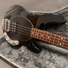 Black electric bass guitar with rosewood fretboard and chrome hardware in a gray plush-lined hard case