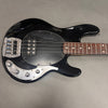 Black electric bass guitar with rosewood fretboard, four strings, and chrome control knobs on a gray background