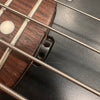 Close-up of bass guitar strings and dark wood fretboard with metal frets and white dot inlay on Coffee House Guitars instrument