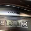 Close-up of DYMO digital scale showing guitar weight as 10 pounds 10 ounces for Coffee House Guitars product listing.
