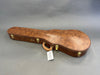 Brown vintage-style hard guitar case with leather handle and gold latches on gray background
