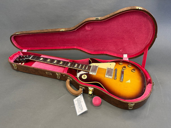 Vintage sunburst electric guitar with humbucker pickups in open brown hard shell case with red velvet interior, guitar case with leather handle and metal latches, coffee house guitars product listing