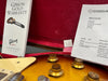 Close-up of Gibson guitar control knobs with Gibson Gold Warranty booklet and Coda invoice in red velvet guitar case interior