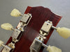 Close-up of vintage guitar tuning machines with cream plastic tuning pegs on a dark wood headstock showing wear and aging details at Coffee House Guitars