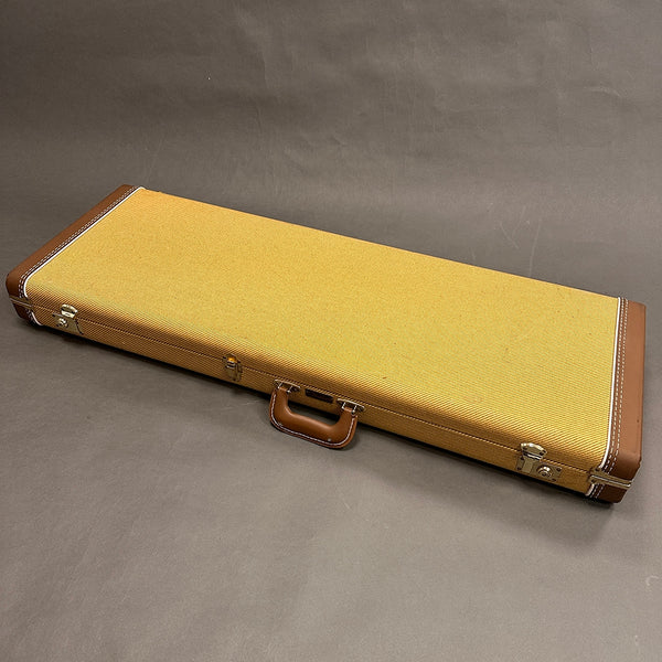 Rectangular vintage-style tweed and brown leather guitar hard case with metal latches and handle on grey background.