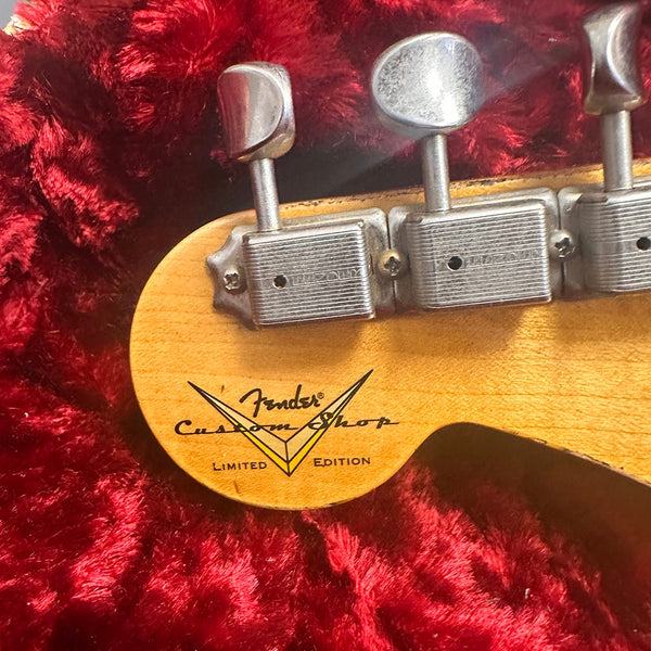 Close-up of Fender Custom Shop Limited Edition guitar tuning pegs on wooden headstock with red plush background