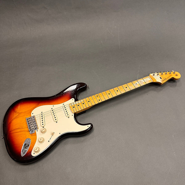Fender Stratocaster electric guitar with sunburst finish, maple neck, and three single-coil pickups on gray background