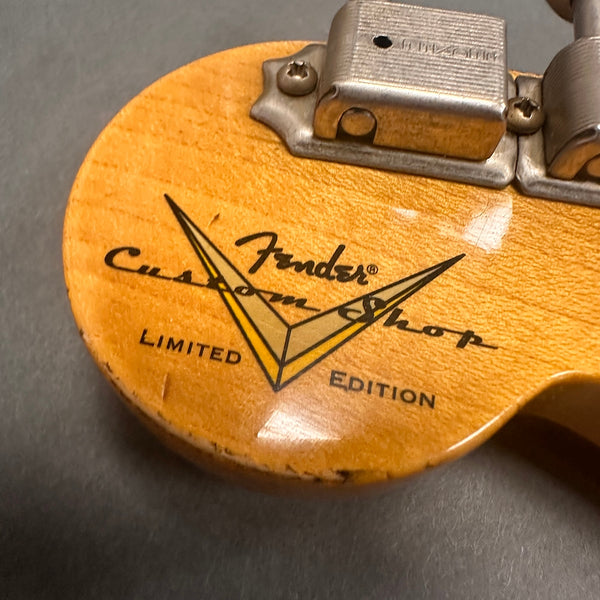 Close-up of Fender Custom Shop Limited Edition logo on the back of a natural wood guitar headstock with vintage tuning pegs