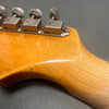 Close-up of vintage guitar headstock showing metal tuning pegs and wood finish with visible scratches and wear marks