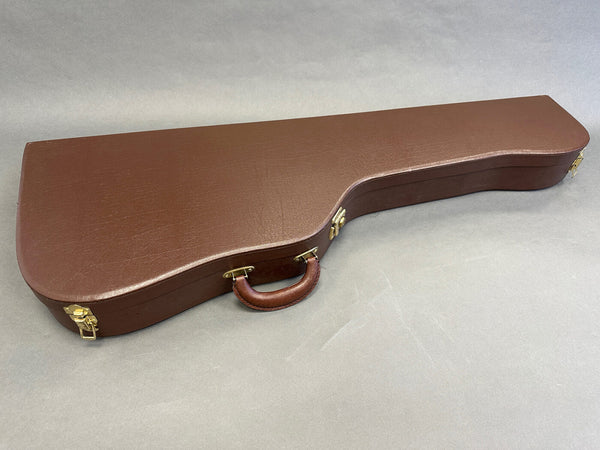 Brown hardshell guitar case with a leather handle and gold latches for acoustic guitar protection