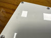 Close-up of white guitar backplate on wood body with serial number 4540 engraved near corner screws