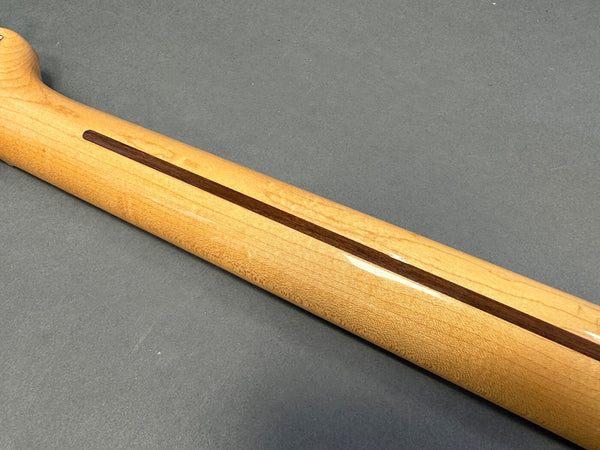 Close-up of maple guitar neck with walnut skunk stripe on gray background