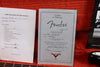 Fender 1969 Stratocaster Certificate of Authenticity and Coffee House Guitars Pre Sales Check List with guitar setup details on red fabric background