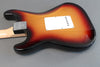 Back view of sunburst electric guitar body with maple neck and white backplate on gray background