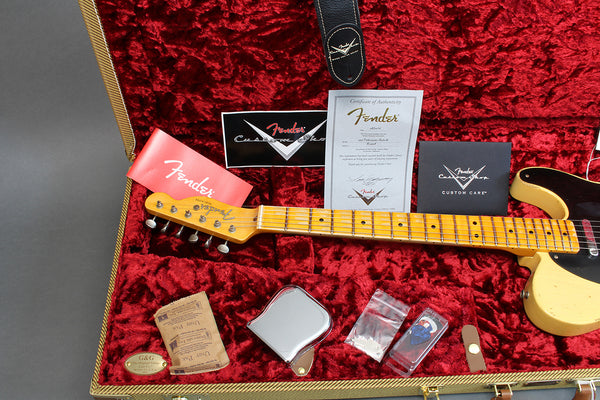 Fender Custom Shop electric guitar in vintage cream color inside red plush guitar case with Fender certificates, guitar strap, metal ashtray, guitar picks, and humidity control pack.