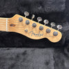 Close-up of Fender Telecaster guitar maple headstock with tuning pegs on black fabric background