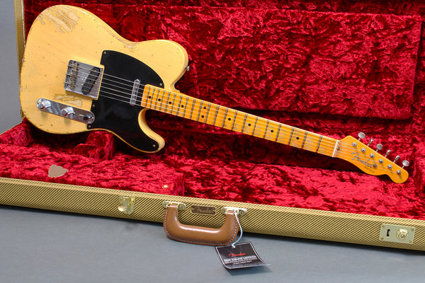 Vintage Fender Telecaster electric guitar with yellow finish and maple neck, displayed in open tweed hard case with red plush interior, featuring black pickguard and chrome hardware