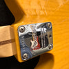 Close-up of Fender guitar neck plate with serial number LF094176 and "Limited Edition Corona, California" engraving on glossy yellow guitar body