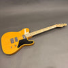 Fender electric guitar with natural wood finish, maple neck, black pickguard, and dual humbucker pickups on gray background