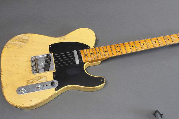Vintage worn yellow electric guitar with black pickguard and maple neck laid on grey background, Coffee House Guitars product listing