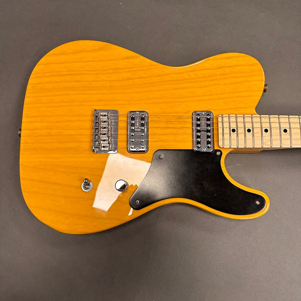 Electric guitar with honey burst finish, black pickguard, dual chrome humbucker pickups, and maple fretboard on dark background
