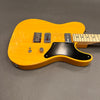 Yellow electric guitar with maple neck and fretboard, black pickguard, dual humbucker pickups, single volume knob, and three-way toggle switch on gray background