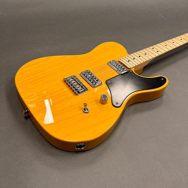 Electric guitar with a bright yellow finish, dual humbucker pickups, black pickguard, single volume knob, and toggle switch on a gray background.